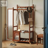 Wooden grace wardrobe rolling coat rack in cherry wood with a mirrored panel holding clothes and accessories