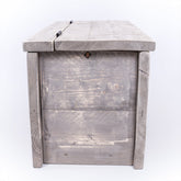 Grey cushion storage wooden clutter box with hinged lid made of distressed wood and visible grain texture