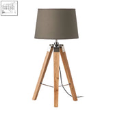 Hadson tripod table lamp with light wood base and matte gray fabric shade featuring metallic accents