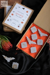 Halloween wax melts with white spiderweb and bat-shaped wax melts in a box with base notes and heart notes