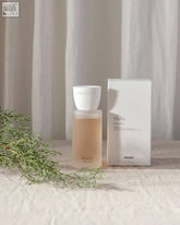 A minimalist white frosted glass bottle of chikidee halo clay home spray with a warm base and matte white cap