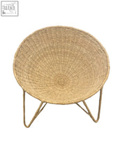 Beige handwoven bucket chair with bowl-shaped wicker seat and thin wire legs perfect for cozy seating