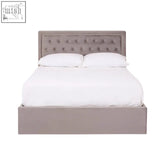 A sleek taupe velvet ottoman bed with tufted headboard and gas lift pistons in a contemporary style