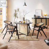 Black round dining table with woven rattan cane base and panels in a sleek modern design perfect for dining rooms