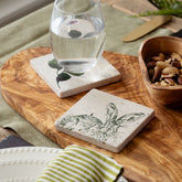 Hare single stone coaster made of natural limestone with black engraved rabbit and leaf design heat resistant
