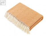 A soft tan herringbone merino lambswool throw with cream fringe perfect for cozying up at home