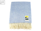 A soft light blue herringbone pure new wool throw with cream fringe and a woven label