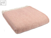 A soft dusky pink pearl herringbone pure new wool throw with cream fringe perfect for cozying up