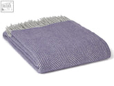 A soft herringbone pure new wool throw blanket in lavender silver with light gray fringe perfect for cozying up