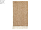 A camel herringbone shetland pure new wool throw with a soft textured weave and cream fringe along the bottom edge