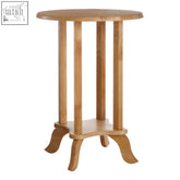 Light-colored wooden heva round tropical side table with four slender legs and a lower shelf made of tropical hevea wood