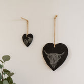 Black heart slate decoration with engraved highland cow and sheep designs hanging by natural twine