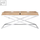 A sleek holland park coffee table with a light wood top and chrome x-shaped legs for modern living spaces