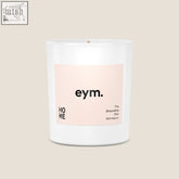 A minimalist white glass standard candle jar with a pale pink eym label called the grounding one 100 percent natural