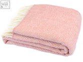 A soft dusky pink honeycomb pure new wool throw blanket with cream-colored fringe perfect for cozying up