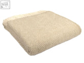 Beige woven honeycomb pure new wool throw with textured herringbone pattern and fringed edges in oatmeal color