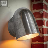 Industrial-style Hopton pewter mast down light solid cast wall sconce with matte textured finish and warm glow inside
