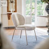 Cream-colored plush sheepskin horatio dining chair with sleek metal frame ideal for stylish dining spaces