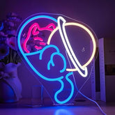A glowing heart-shaped neon sign featuring a pink cat, blue astronaut, and yellow planet perfect for cat lovers bedroom neon light
