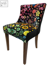 A vibrant floral-patterned horton chair with black base and wooden legs perfect for stylish living spaces