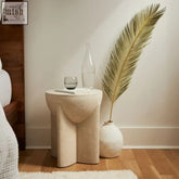 Beige textured stone hotila side table with sculpted organic curves and tapered legs for stylish storage
