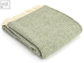 A soft sage green grey wool throw blanket with textured weave and cream fringe 183cm including fringe perfect for cozying up