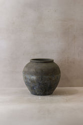 A rustic dark gray ceramic indonesia pot no 28 with rounded body and slightly textured surface