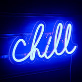 A glowing blue chill neon wall light in cursive script perfect for bedroom bar game room decor