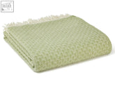 A soft light green woven isobel crescent pure new wool throw with textured pattern and cream fringe