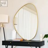 Gold metal irregular shape izumi mirror with a sleek frame resting on a black console table, 120cm x 90cm