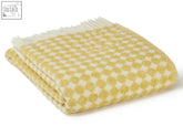 A soft jacquard spot pure new wool throw blanket in oil yellow with cream checkered spot design and white fringe edges