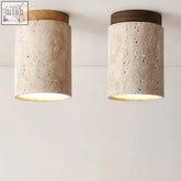 Two cylindrical concrete ceiling lights with wooden caps in light and dark wood from kaku light collection