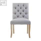 Grey linen dining chair with tufted grey linen upholstery and light wood legs perfect for dining spaces