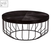 Black round coffee table with dark wood hair on hide top and black metal wireframe base for stylish living rooms