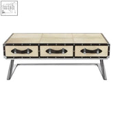 Cream-colored kensington townhouse mango wood coffee table with three drawers black leather handles and metal legs