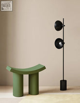 Modern black floor lamp with two circular shades and slender pole next to a kimber footstool dressing table stool