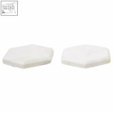 Two off-white hexagonal silicone pads with a smooth finish from kindia white marble hexagonal coasters set