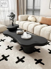 Black matte-finished kohee coffee table with organic flowing contours and single cylindrical base perfect for cozy spaces