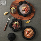 Black volcanic stone serving plates with copper mesh floral insets from kubalo tableware collection for culinary creations