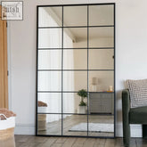 Black metal rectangle lattice grid mirror with multiple panes reflecting room interior 180cm by 105cm