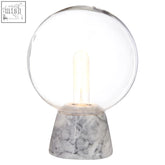 Lamonte globe lamp with a clear glass globe and exposed bulb on a sleek grey marble base