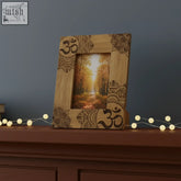 A light brown mango wood photo frame 13x18cm with dark mandala and ohm designs showing autumn forest path