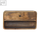 A large floating curve open slot bedside table made of solid mango wood with warm brown tones and a black knob