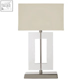 Laurel table lamp with beige fabric shade, clear acrylic geometric base, and polished stainless steel accents