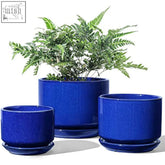 Set of three sapphire blue ceramic planters with drainage holes and matching saucers featuring speckled glaze finish