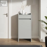 Minimalist gray leach shoe storage cabinet with small drawer and white vase holding dried branches on top
