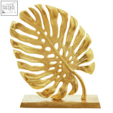 Gold finish monstera leaf sculpture by lena prato with matching gold base for stylish home decor