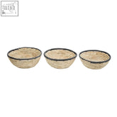 Set of three palm leaf baskets with black trim featuring woven natural fiber and dark rim accents