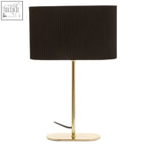 Black ribbed lampshade on a shiny brass table lamp with a slender metal base and oval foot for stylish lighting