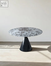Lillian round dining table with a sleek black and white marble top and glossy black conical base dining table